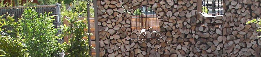 Holzstapel als Sichtschutz im Garten